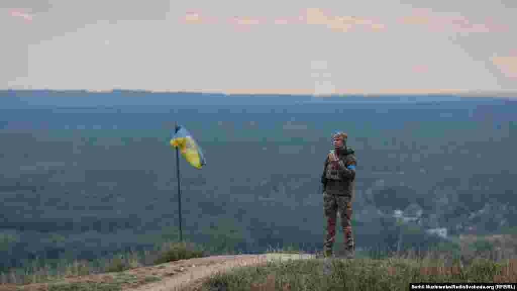 На іншому боці пагорба український військовий спілкується з кимось із рідних&nbsp;