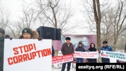 Аслан Жамалиев Оралдағы митинг кезінде «Stop corruption» дейтін жазуы бар плакат ұстап тұр. 8 желтоқсан 2019 жыл.