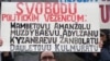 Прагада наразылық жиынына шыққан қазақ босқындарының бірі «Қазақстан 2010 жылы ЕҚЫҰ-на төрағалық етеді. МАСҚАРА» деген жазу ұстап тұр. Ақпан, 2009 жыл.