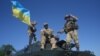 Ukraine – soldiers (C and R) and an Ukrainian soldier climb on an armored military vehicle as they attend the joint military exercises 'Rapid Trident 2016' at the Yavoriv training ground, near the western Ukrainian city of Lviv, 04 July 2016