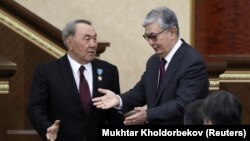 Нұрсұлтан Назарбаев (сол жақта) Қазақстан президенті қызметінен кетіп, бұл міндетті уақытша атқаруды соған дейін парламент сенаты төрағасы болып істеген Қасым-Жомарт Тоқаевқа тапсырды. Астана (қазіргі Нұр-Сұлтан), 20 наурыз 2019 ж.