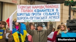 Гасло: «Тюркські народи, українці, поляки, єднайтеся у боротьбі проти спільного ворога – путінської агресії. Польща. Україна. Татарстан» Нафіс Кашапов, активіст із Татарстану, під час демонстрації у Варшаві, 23 листопада 2014 рок