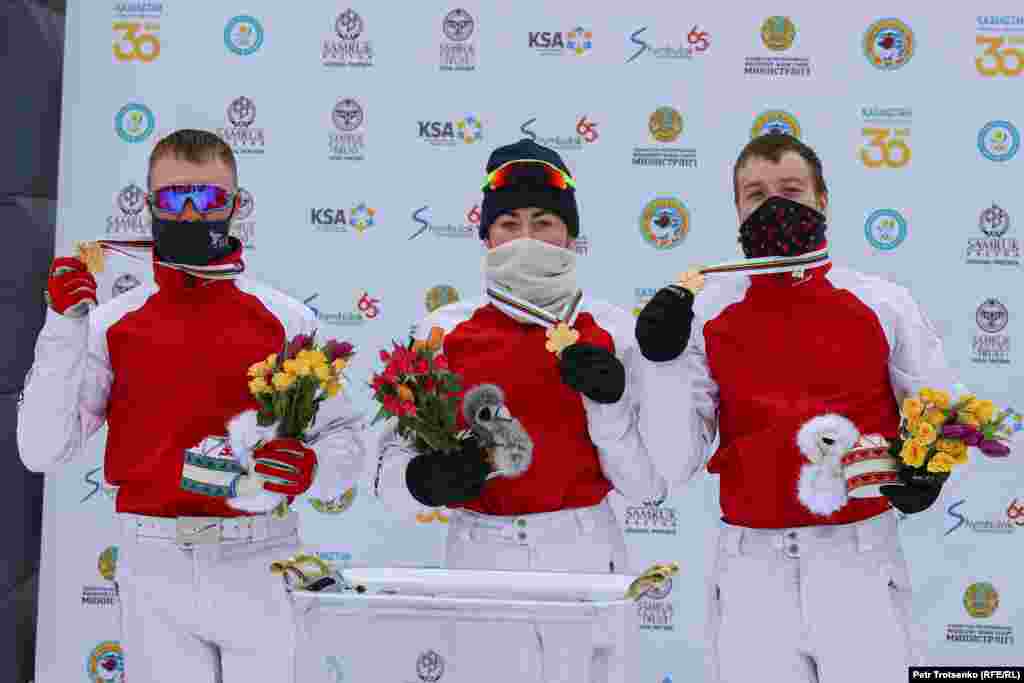 Ресейлік спортшылар Павел Кротов (солдан оңға қарай), Любовь Никитина мен Максим Буров фристайлдан әлем чемпионатының алтын медалін иеленді. Алматы, 11 наурыз 2021 жыл.