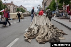 Майдан белсенділері алаңнан жинап алынған шатырды әкетіп барады. Киев, 28 мамыр 2014 жыл.