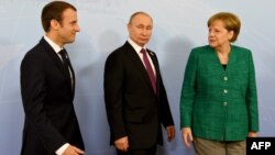 Almaniya kansleri Angela Merkel (sağda), Rusiya prezidenti Vladimir Putin(ortada) və Fransa prezidenti Emmanuel Macron 