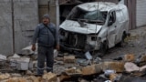 CORRECTION / A man stands among debris next to a destroyed car following a drone attack in Odesa on November 10, 2024, amid the Russian invasion in Ukraine.