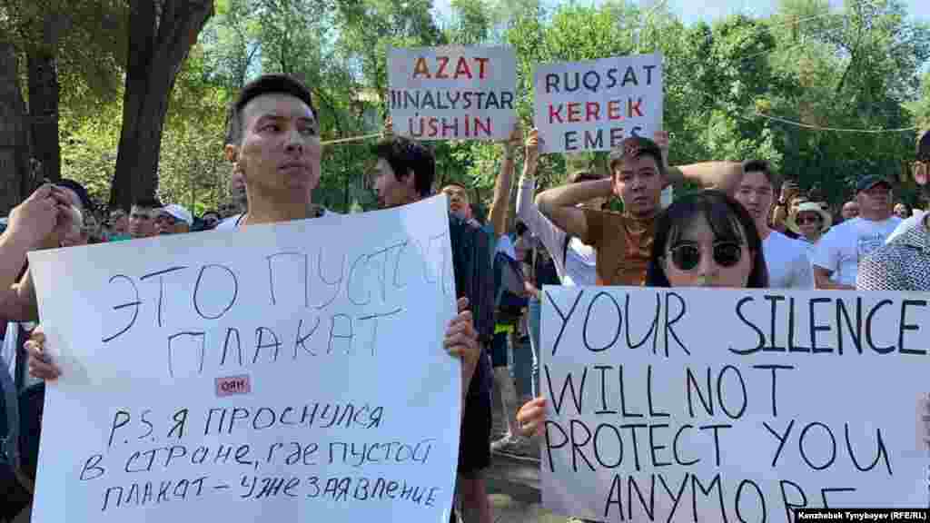 &quot;Үнсіздік ендігәрі сені қорғай алмайды&quot; деген жазуы бар плакат ұстап тұрған азамат.&nbsp;