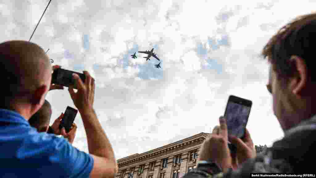 Глядачі фотографують проліт над Хрещатиком важкого військово-транспортного літака Іл-76 у супроводі багатоцільових винищувачів Су-27