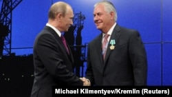 Владимир Путиннің (cол жақта) Ресей премьер-министрі кезінде Exxon Mobil басшысы Рекс Тиллерсонмен кездескен сәті. Ресей, Сочи, 30 тамыз 2011 жыл.