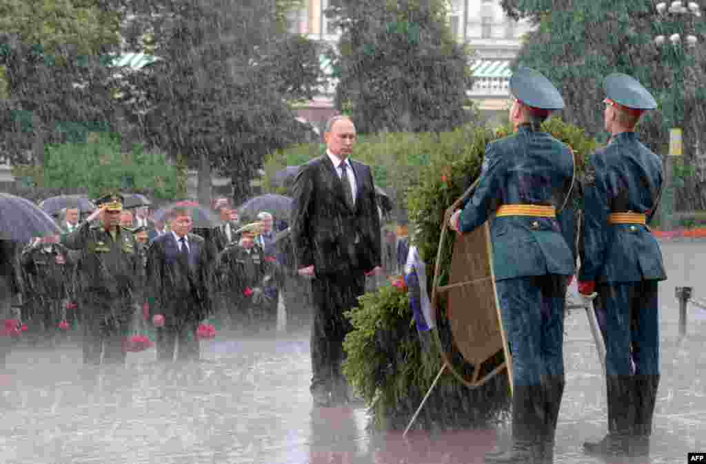 Германиялық нацистердің Совет Одағына басып кіруіне 76 жыл толуына орай Мәскеуде өткен қаралы жиын кезінде Ресей президенті Владимир Путин Белгісіз солдат қабірі алдында қалың нөсердің астында тұр. 22 маусым 2017 жыл. Алексей Дружинин 22 маусым күні таңертең Мәскеуде күн салқын әрі ауа райы құбылмалы болды деп еске алады. Фотограф &quot;Мәңгілік алау&quot; басына жеткенде аспан шайдай ашылған. Бірақ президент бастаған делегация гүлдестеге жақындаған сәтте жаңбыр шелектеп құйып кеткен. Автор Азаттықтың Орыс қызметіне Мессенджер арқылы жұрттың әлгі фотосуреттегі қолшатырсыз Путинді қызу талқылағанын айтқан. Кейінірек Путиннен &quot;Қолшатырдан неге бас тарттыңыз?&quot; деп сұрағанда, әрдайым өзін &quot;мықты адам&quot; етіп көрсететін ол: &quot;Еріп кететін қант емеспін ғой&quot; деп жауап берген.